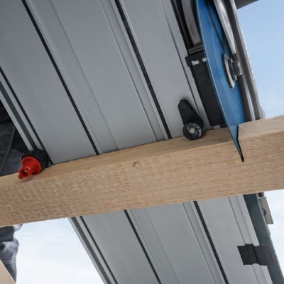 Mala rígida cinza com rodas sobre estrutura de madeira