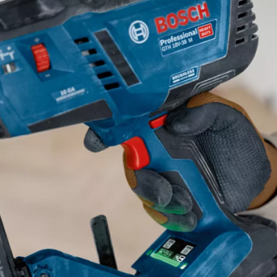 Ferramenta elétrica azul BOSCH Professional com luvas a segurá-la