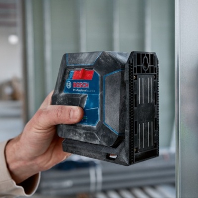 Ferramenta de medição a laser BOSCH Professional numa mão junto a estrutura metálica