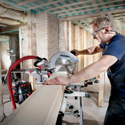 Homem a cortar madeira com serra de esquadria Metabo em construção