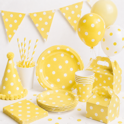 Conjunto amarelo com bolinhas brancas de artigos para festa sobre fundo branco