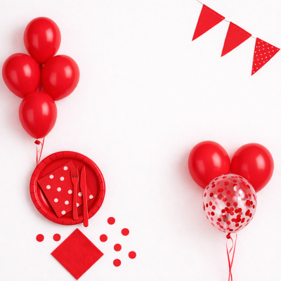 Decoração de festa com balões vermelhos, prato e guardanapos com padrão de bolas brancas e bandeirolas vermelhas numa parede branca