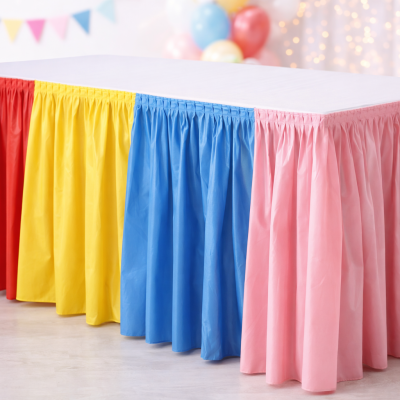 Mesa com saia colorida vermelha, amarela, azul e rosa numa festa