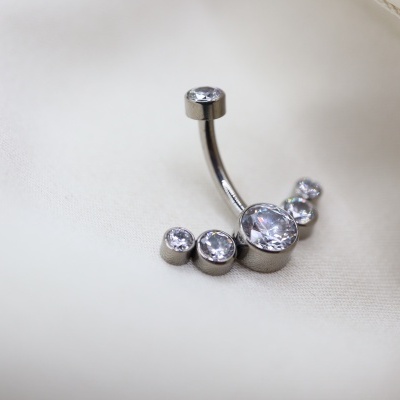 Piercing de umbigo com pedras de strass sobre tecido branco