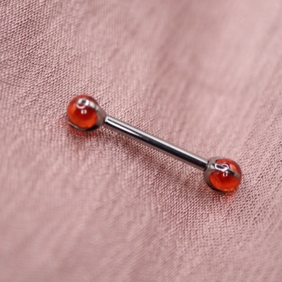 Piercing para língua com bolas vermelhas em tecido rosa