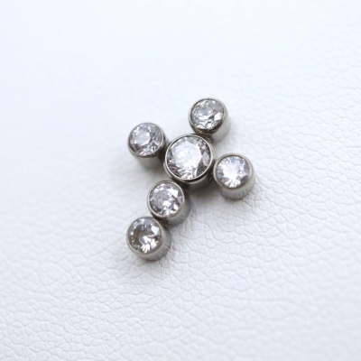 Pingente em forma de cruz com pedras transparentes sobre fundo branco