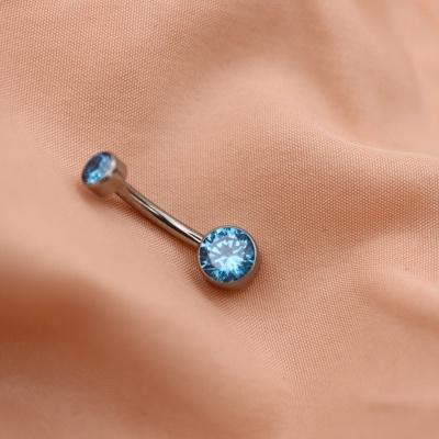 Piercing para umbigo com pedras azuis em tecido cor de pêssego