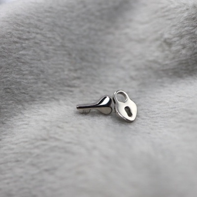 Par de botões de punho em metal prateado sobre tecido cinzento