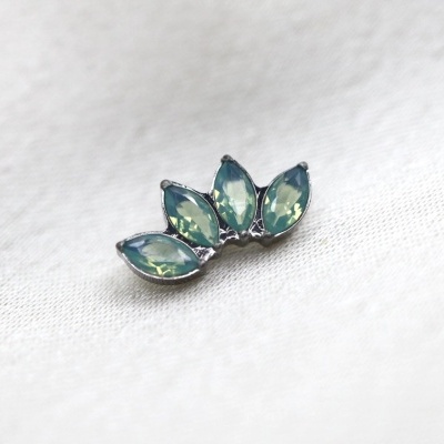 brinco de prata com pedras verdes em tecido branco