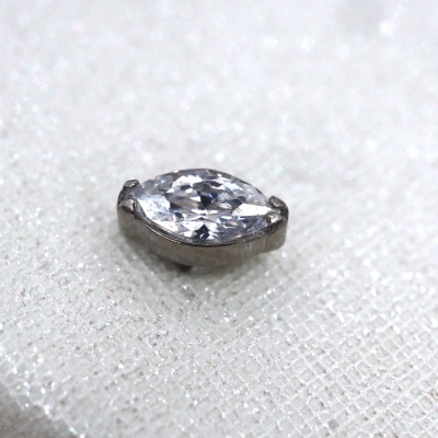 Brilhante corte marquise em base metálica prateada sobre tecido branco texturizado