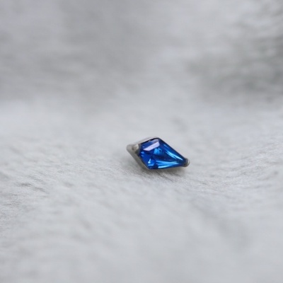 Pedra preciosa azul facetada sobre tecido branco