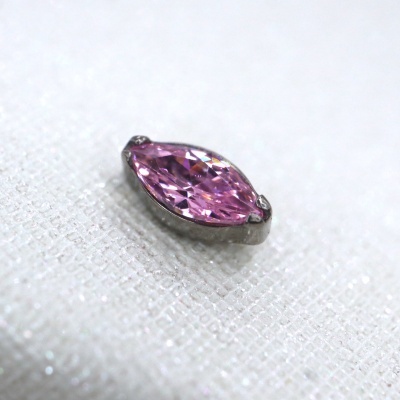 Pendente rosa oval em base metálica sobre tecido branco