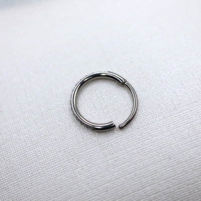 Argola metálica prateada sobre tecido branco