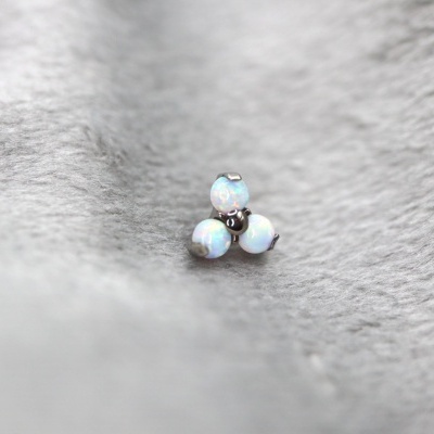 Joia com três pedras opala redondas em fundo cinzento