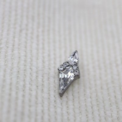 Brinco prateado com pedras brilhantes sobre tecido branco