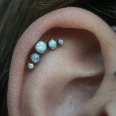 Brinco de cartilagem com pedras opalas em vários tamanhos na orelha