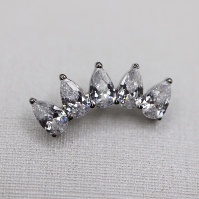 Brinco prateado com pedras transparentes em tecido cinza claro