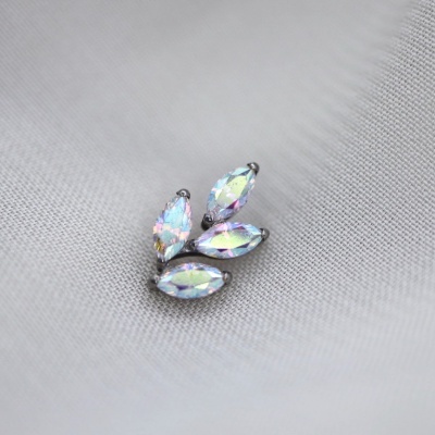 Brincos com pedras ovaladas iridescentes sobre tecido cinza