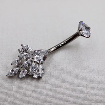 Anel para umbigo prateado com pedras transparentes em fundo cinza