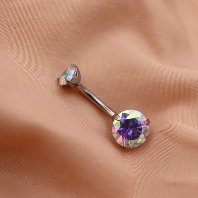 Anel para o umbigo com pedras brilhantes sobre tecido laranja claro