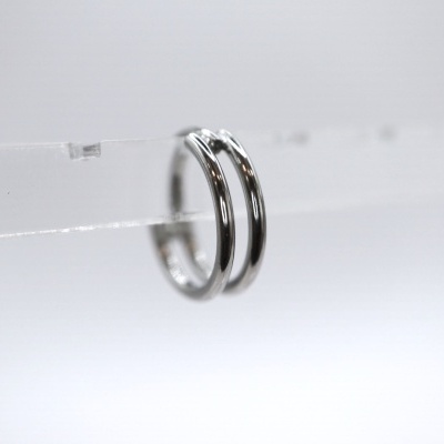 Par de brincos de argola prateados em suporte transparente