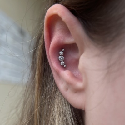 Orelha com piercing de prata com cinco pedras redondas alinhadas