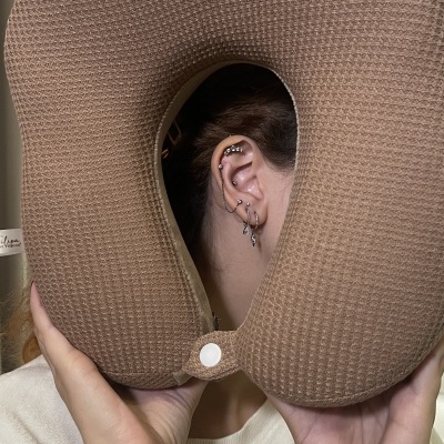 Almofada de viagem castanha em formato de U com textura waffle