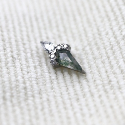 pendente com pedra verde e pedras transparentes em tecido branco riscado