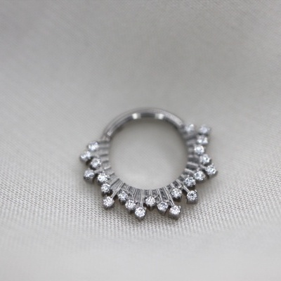 Anel prateado com pérolas sobre tecido cinzento claro