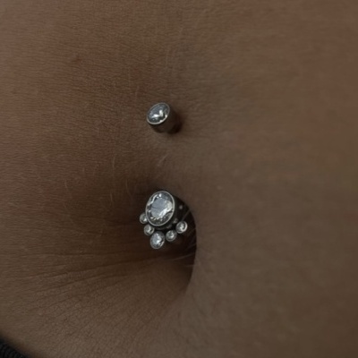 Piercing de umbigo com pedras transparentes em pele castanha
