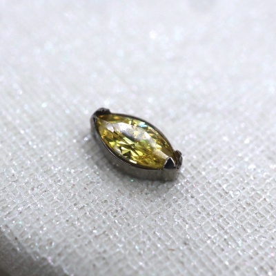 pedra preciosa amarelo-claro em formato navete sobre tecido branco