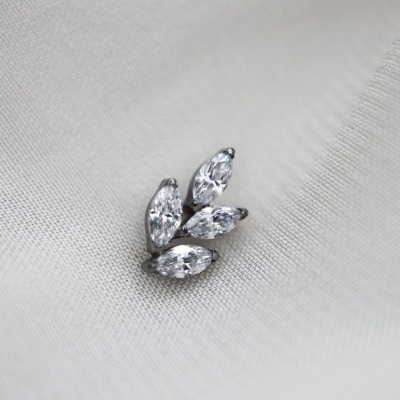 Brinco prata com quatro pedras transparentes sobre tecido branco