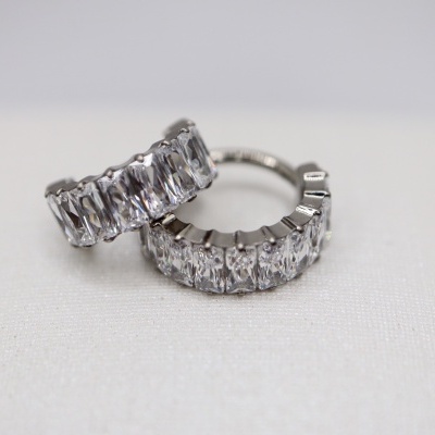 Par de brincos argola prateados com pedras retangulares sobre fundo branco