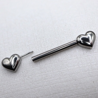 Par de brincos prateados em forma de coração sobre tecido branco