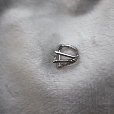 Engate metálico prateado sobre tecido cinzento