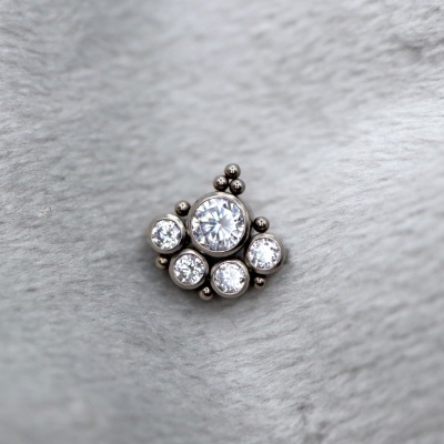 Peça de joalharia prateada com pedras redondas