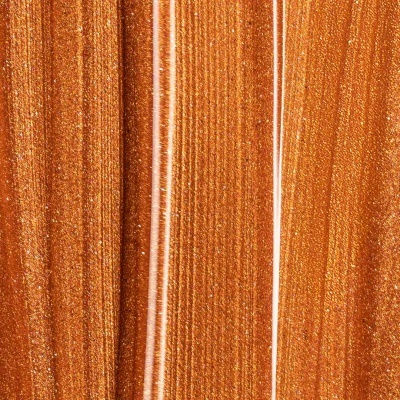 Superfície metálica brilhante em tons bronze e dourado com riscas verticais