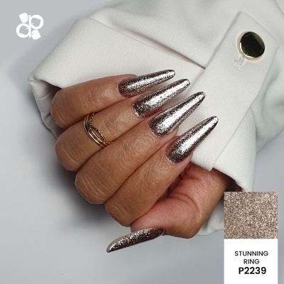 Mão com unhas longas de verniz prateado glitter e anel dourado