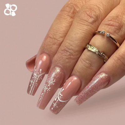 Unhas compridas rosa com desenhos brancos de flocos de neve e glitter rosa