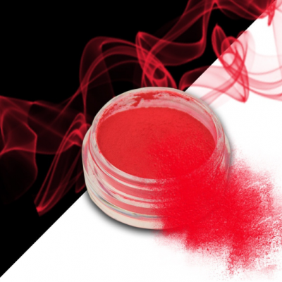 Pó pigmentado vermelho em recipiente redondo com pó espalhado e fumaça vermelha ao fundo