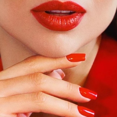 Boca com batom vermelho e unhas com verniz vermelho