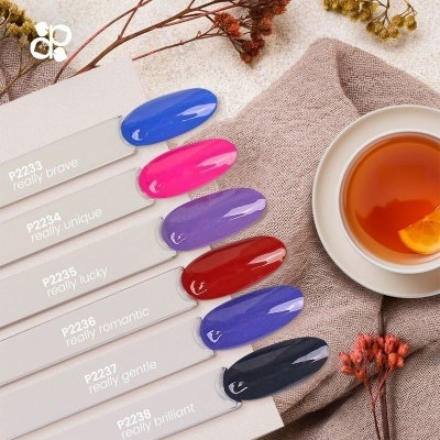 Mostruário com seis cores de verniz, chá numa chávena branca e flores secas