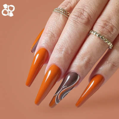 Unha decorada em tons laranja e castanho com anéis dourados