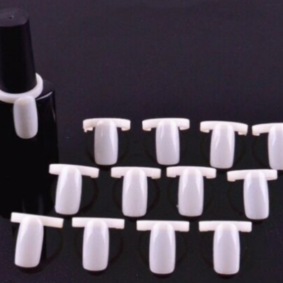 Amostras de unhas de plástico branco e frasco de esmalte preto em fundo preto