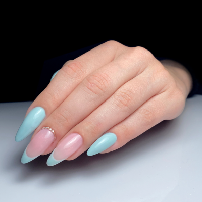 Unhas almendradas pintadas de azul claro e rosa com decoração brilhante.