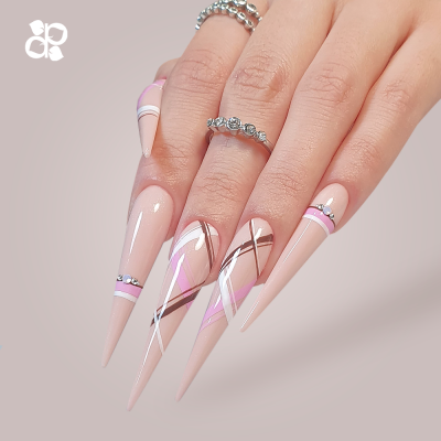 Mão com unhas artificiais compridas e decoradas em nude, rosa, branco e metalizado com anéis prateados