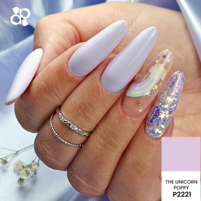 Unhas decoradas com verniz lilás, arco-íris e glitter holográfico sobre fundo lilás e flores brancas