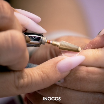 Máquina elétrica para manicure em uso em unhas cor de rosa claro