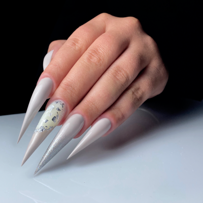 Mão com unhas artificiais longas em diferentes cores e texturas sobre fundo preto.