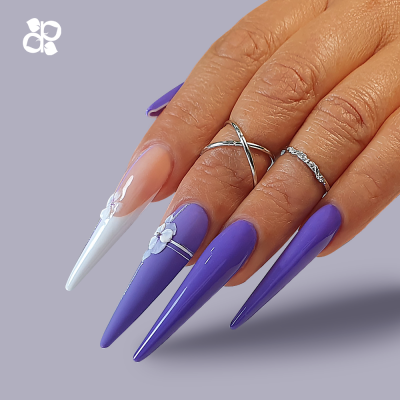 Unhas longas stiletto decoradas em roxo e branco com anéis prateados